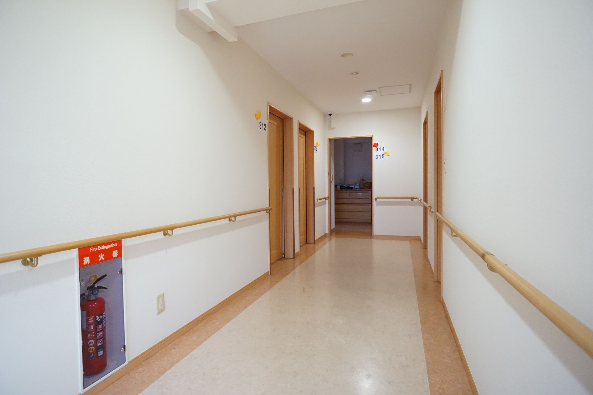 両側の白い壁に木製の手すりが付いている廊下