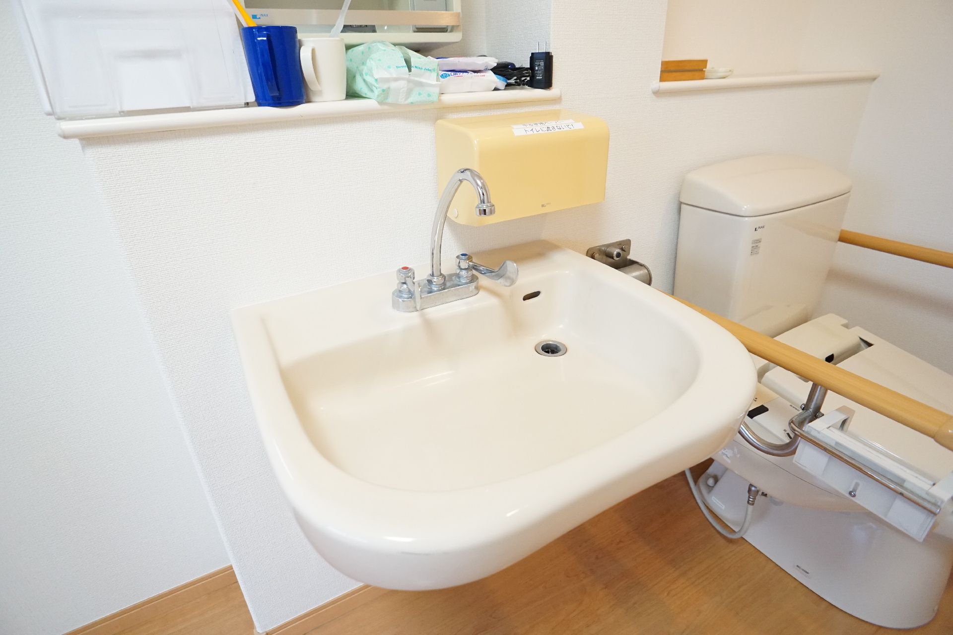 トイレの手前の白い壁に配置された洗面器
