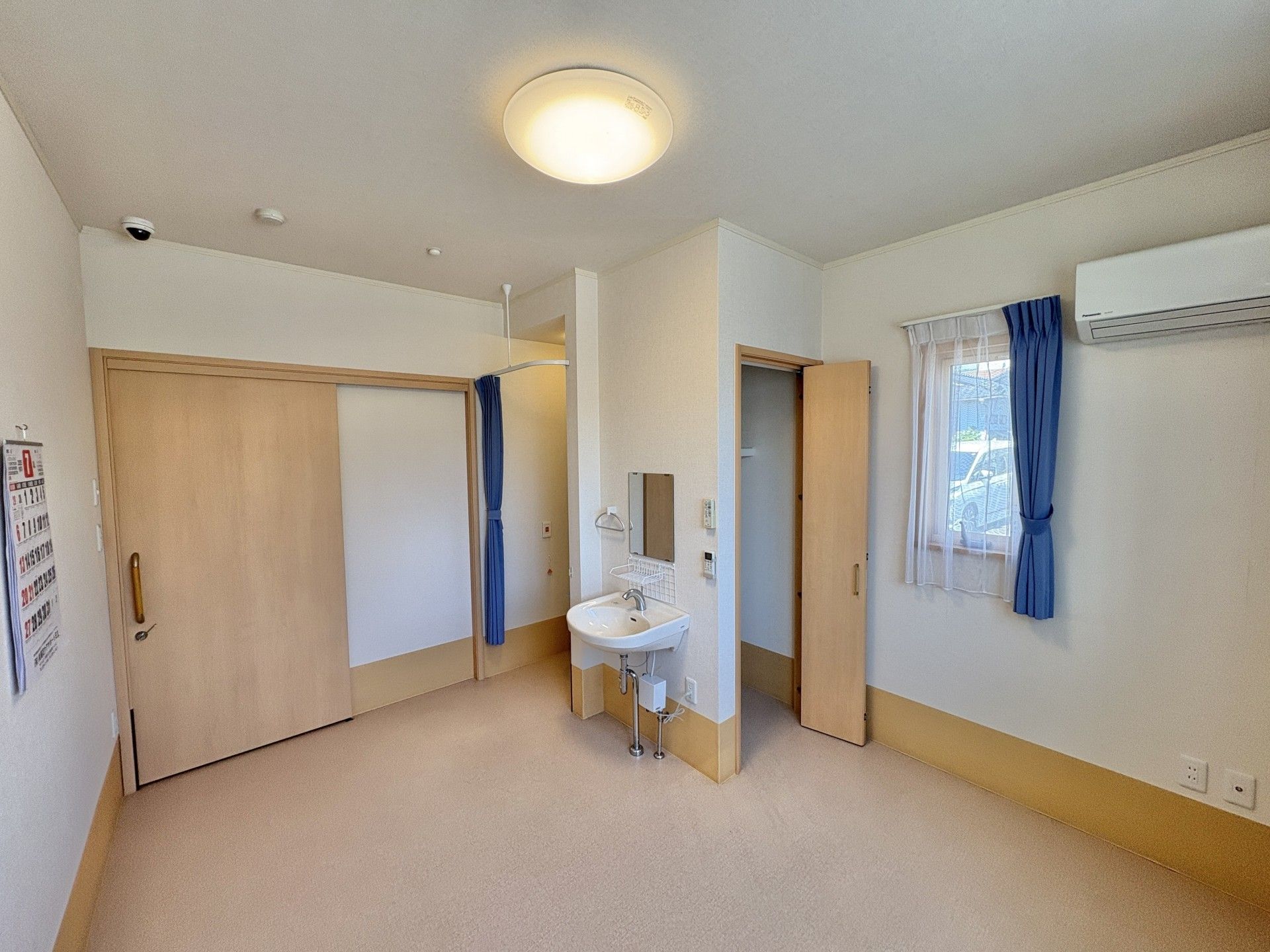 エプロンを付けた若い女性スタッフが車いすの高齢女性が屋外で笑顔で過ごしている。