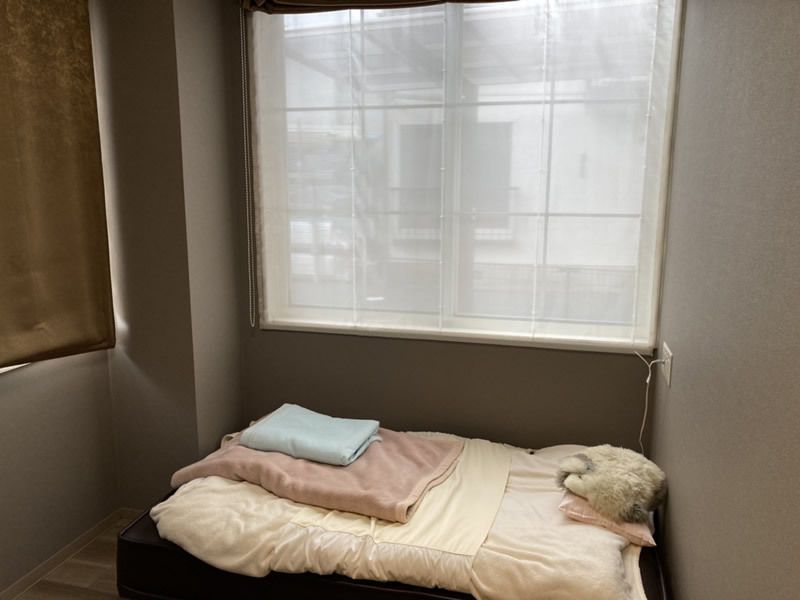 寝具付きのベッドが置かれたコンパクトな部屋には大きな窓があり、明るい雰囲気。