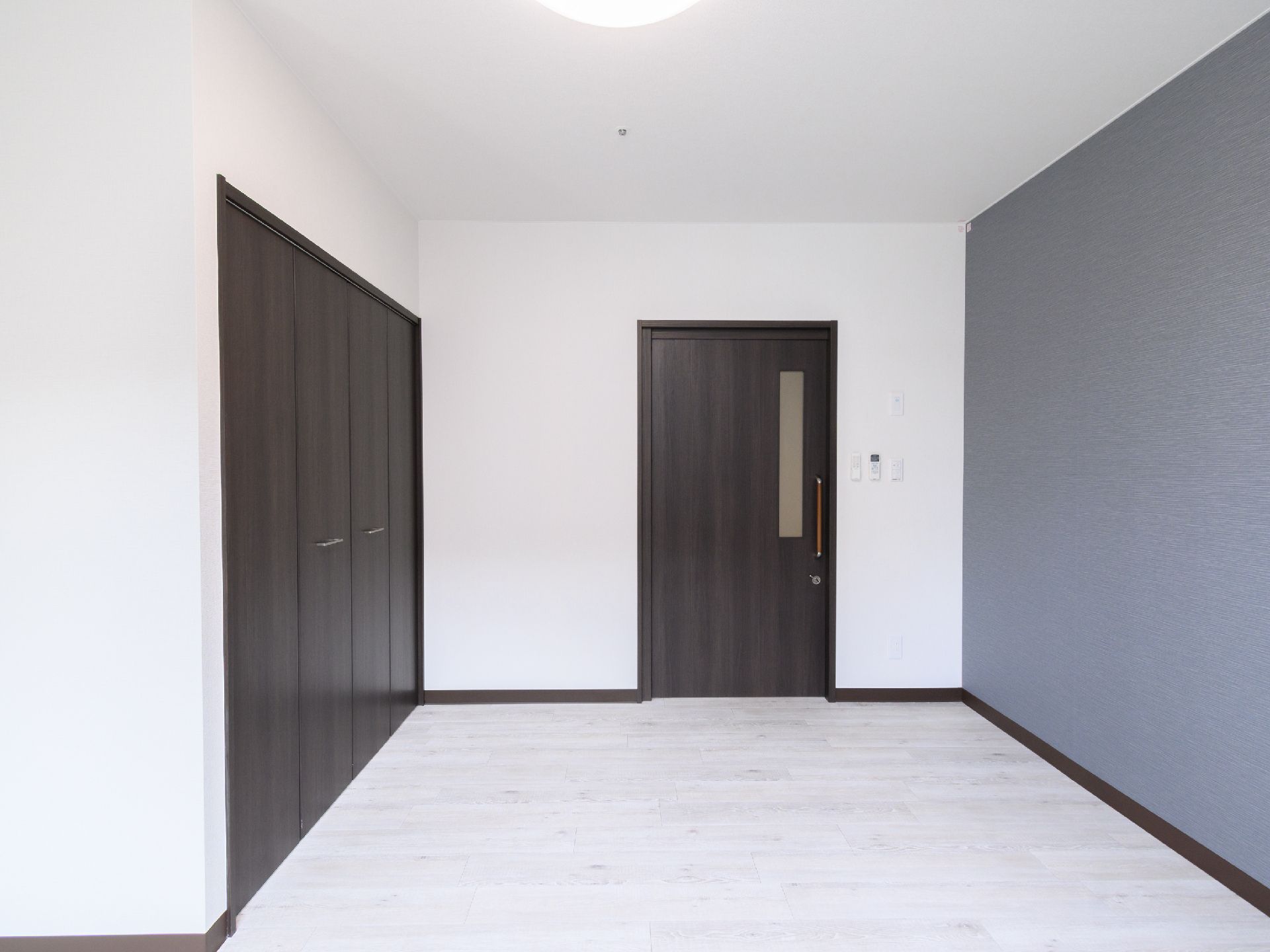 黒い扉が付いた白い壁の何も置かれていない部屋