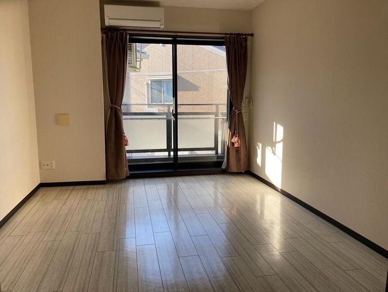 エアコンが付いたフローリングの部屋にはカーテンが付いた窓が設置され、家具などは置かれていない。