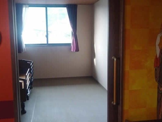 介護ベッドが置かれた居室にはカーテンが付いた窓が設置され、入居者の私物はない。