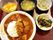大きな具沢山のカレーはボリュームがあり、ヒジキの煮物やみそ汁、野菜の煮物、フルーツのようなものがある。