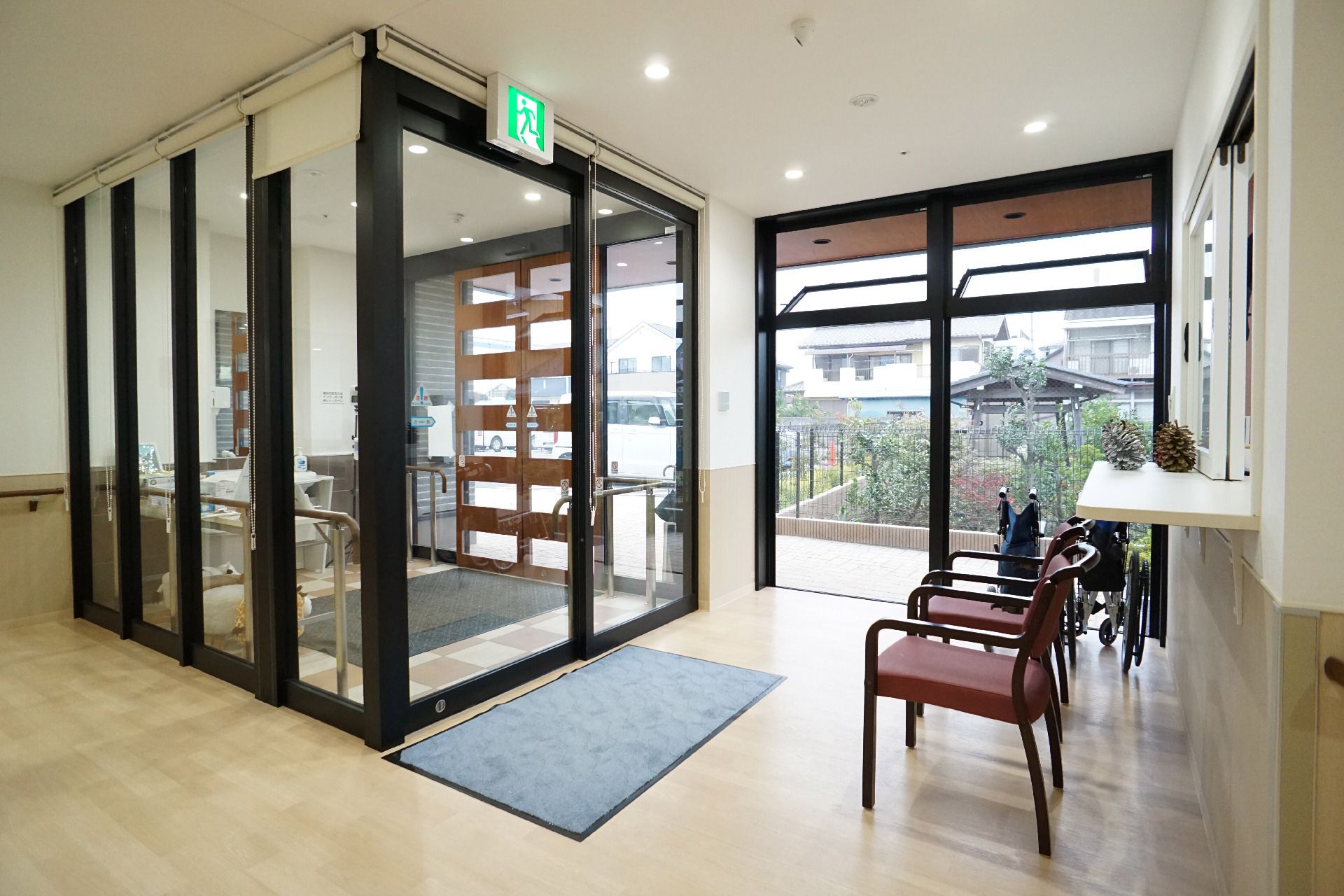 福祉車両を降りようとしている眼鏡をかけた高齢男性のサポートに当たっている若いスタッフ。