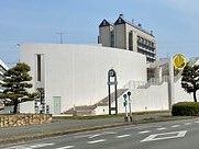 白を基調とした建物には窓があまりなく、モダンなデザイン。道路に面して建っている。