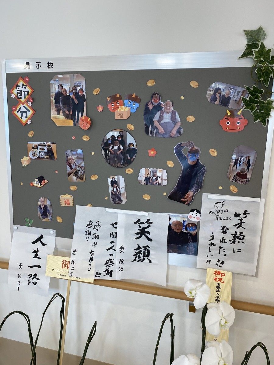 お祝いの花が飾られている共有スペース。節分の時に撮影された写真がたくさん飾られている。