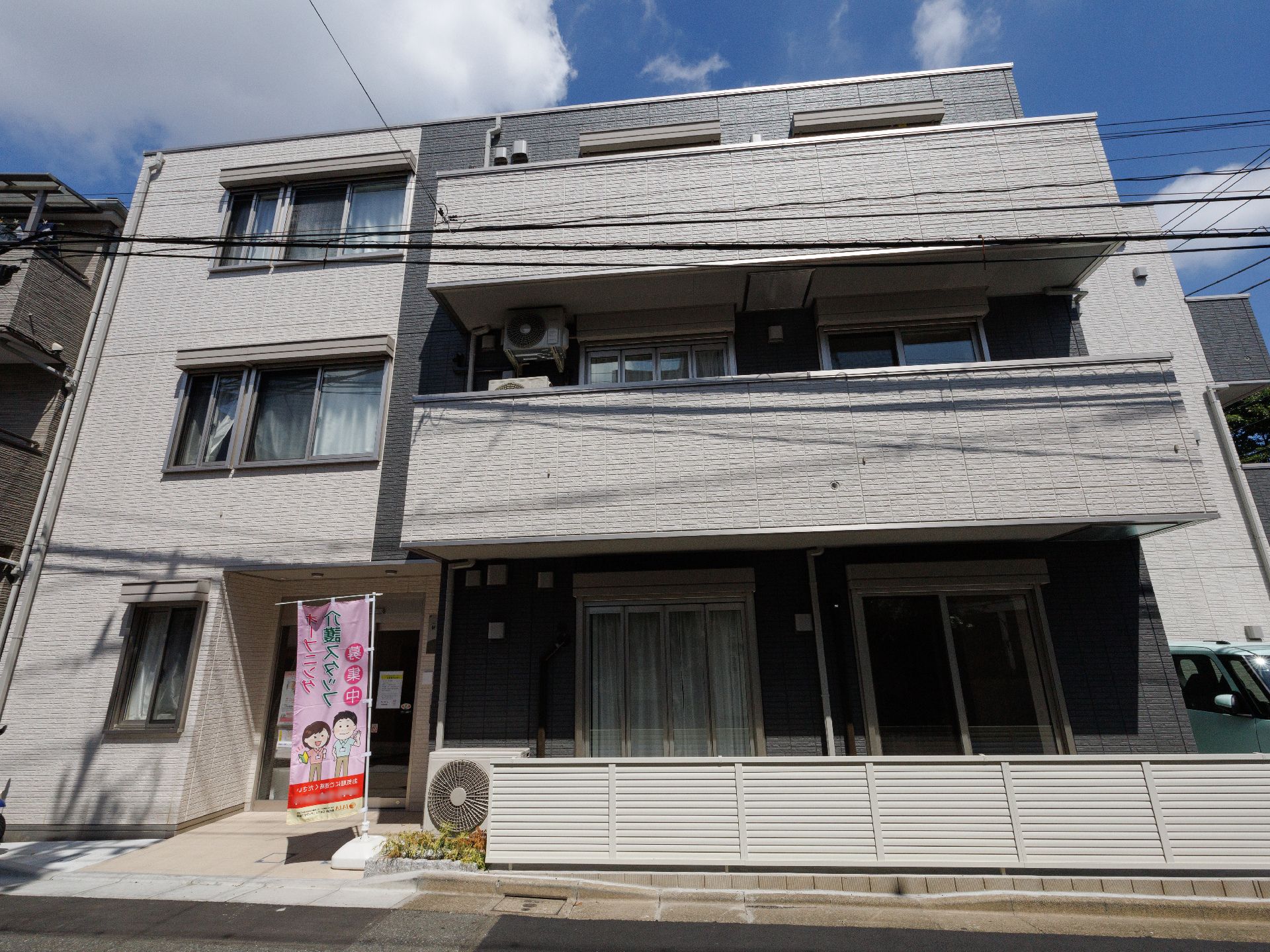 モノトーンの色調をした３階建てのグループホーム