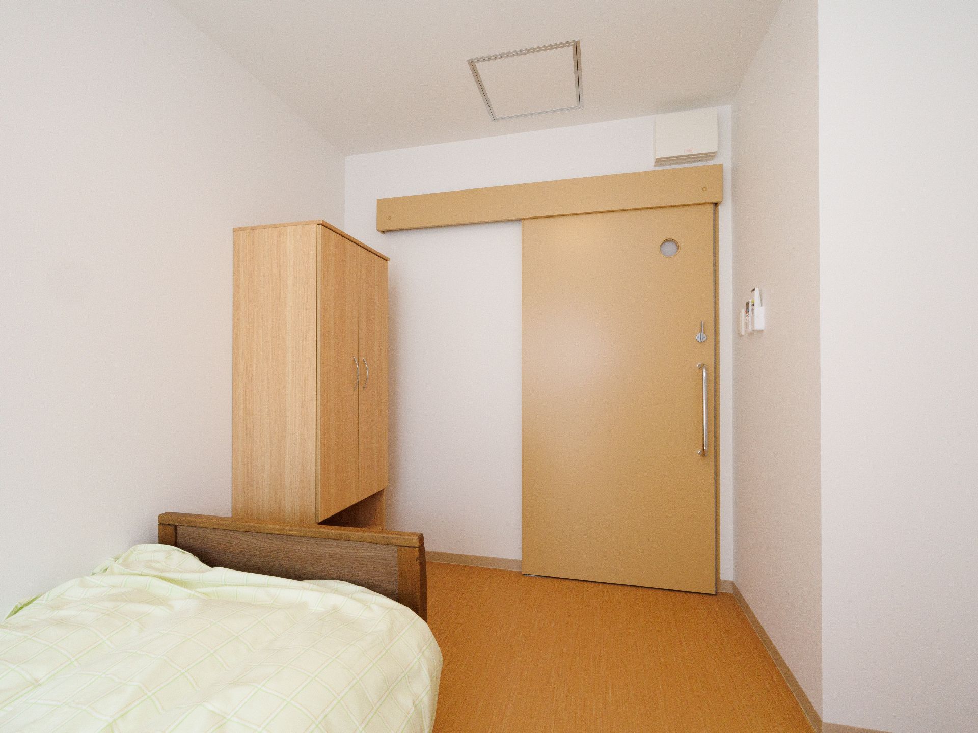 髪の長い女性スタッフが手を差し出し、その手を見て笑っている車いすの高齢女性。
