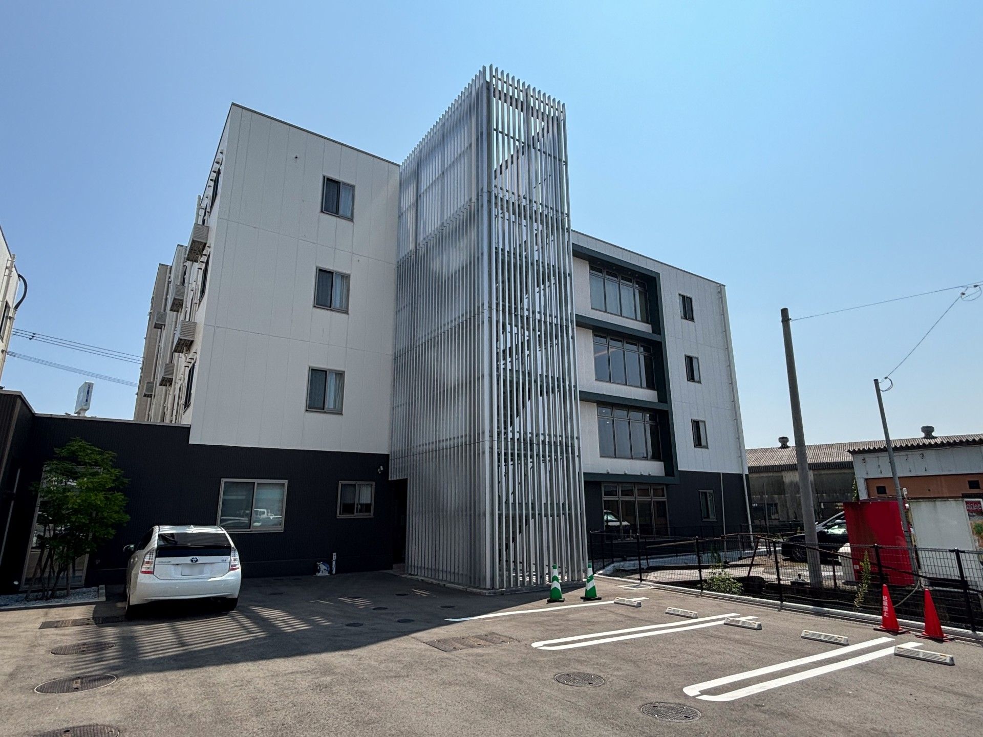大きな窓がたくさん付いたデイサービスのフロアには家具や家電は置かれていない。壁には手すりが付いている。