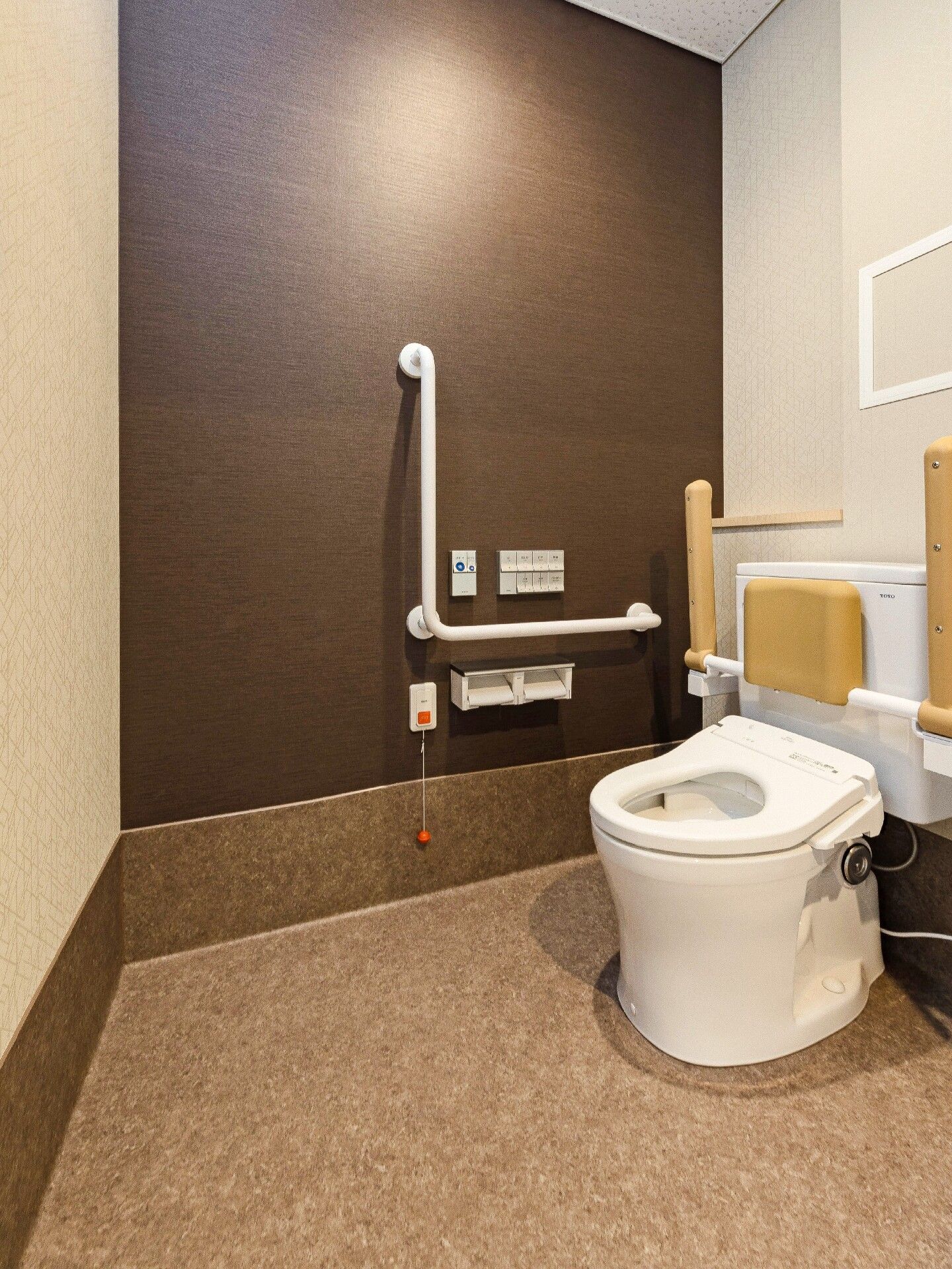 車いす対応の洗面所やトイレが設置された居室はフローリングのフロアで一部グリーンのクロスが貼られている。