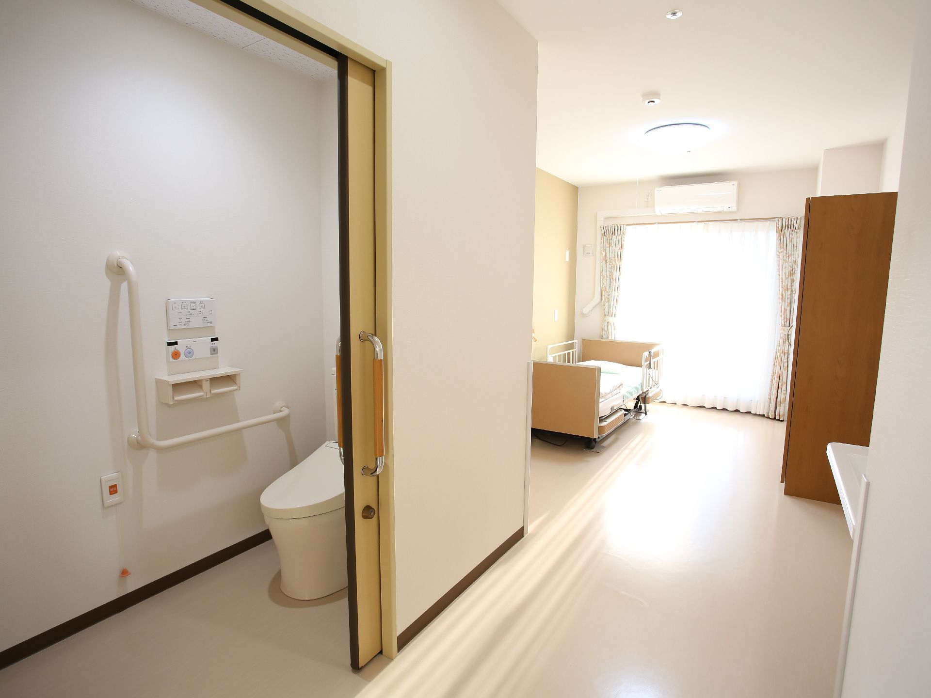 介護ベッドが置かれ、テーブルや椅子が設置されている居室