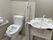 両サイドに手すりが付いた広いトイレ。トイレのふたには消毒済みのカバーがされている。