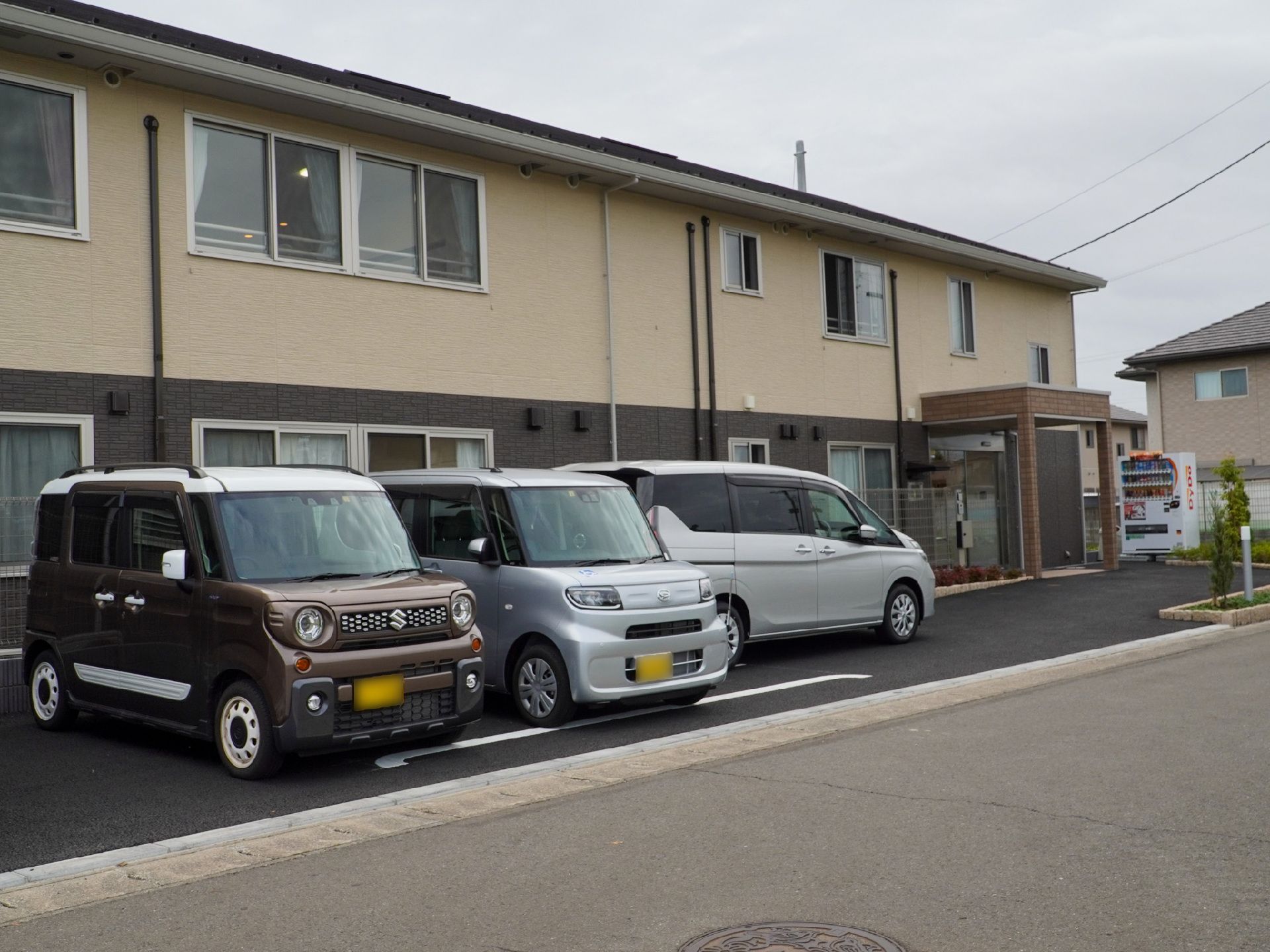 1階部分がブラウン、2階部分がベージュの2階建ての建物