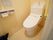 引き戸が付いたトイレには二連式のトイレットペーパーホルダーや操作ボタンが壁についている。