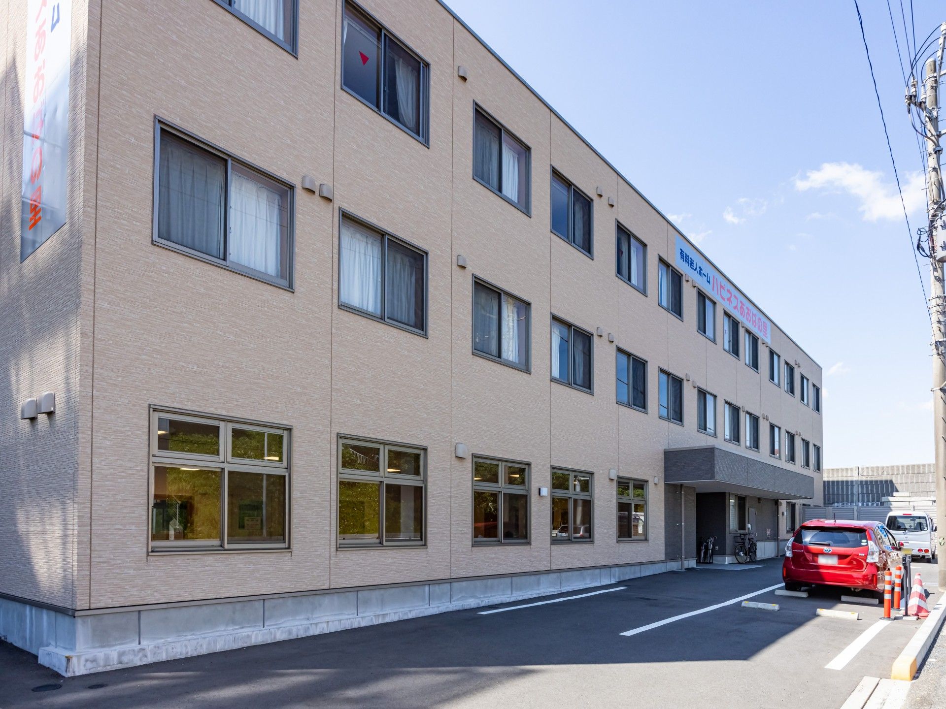 車いすの高齢の男女が屋外で笑顔で何かを鑑賞している。そばにはエプロンを付けた男女のスタッフがいる。