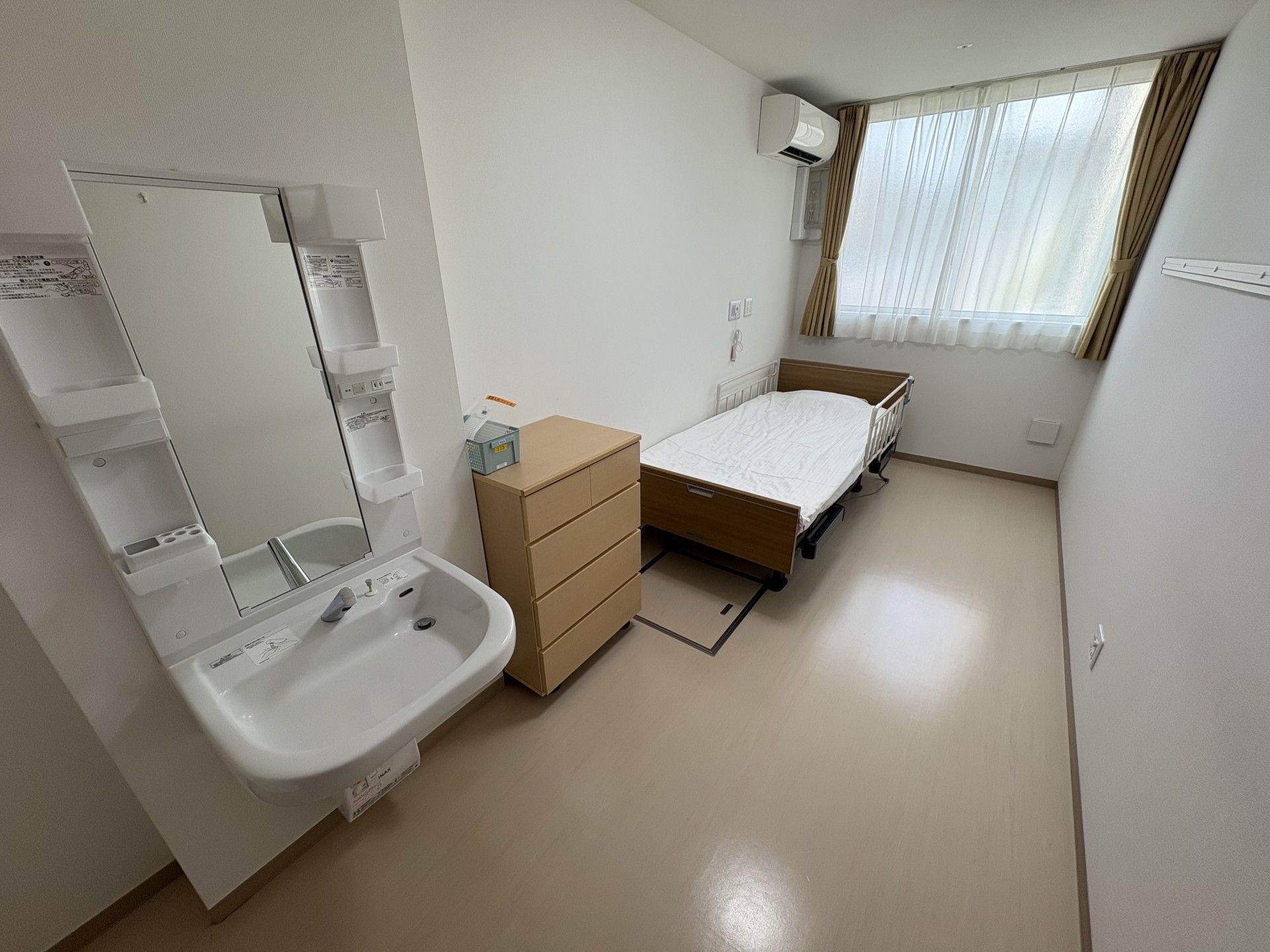 カルテのようなものを見ながら話しているエプロンを付けた若い女性スタッフとカーディガンを着た高齢女性。