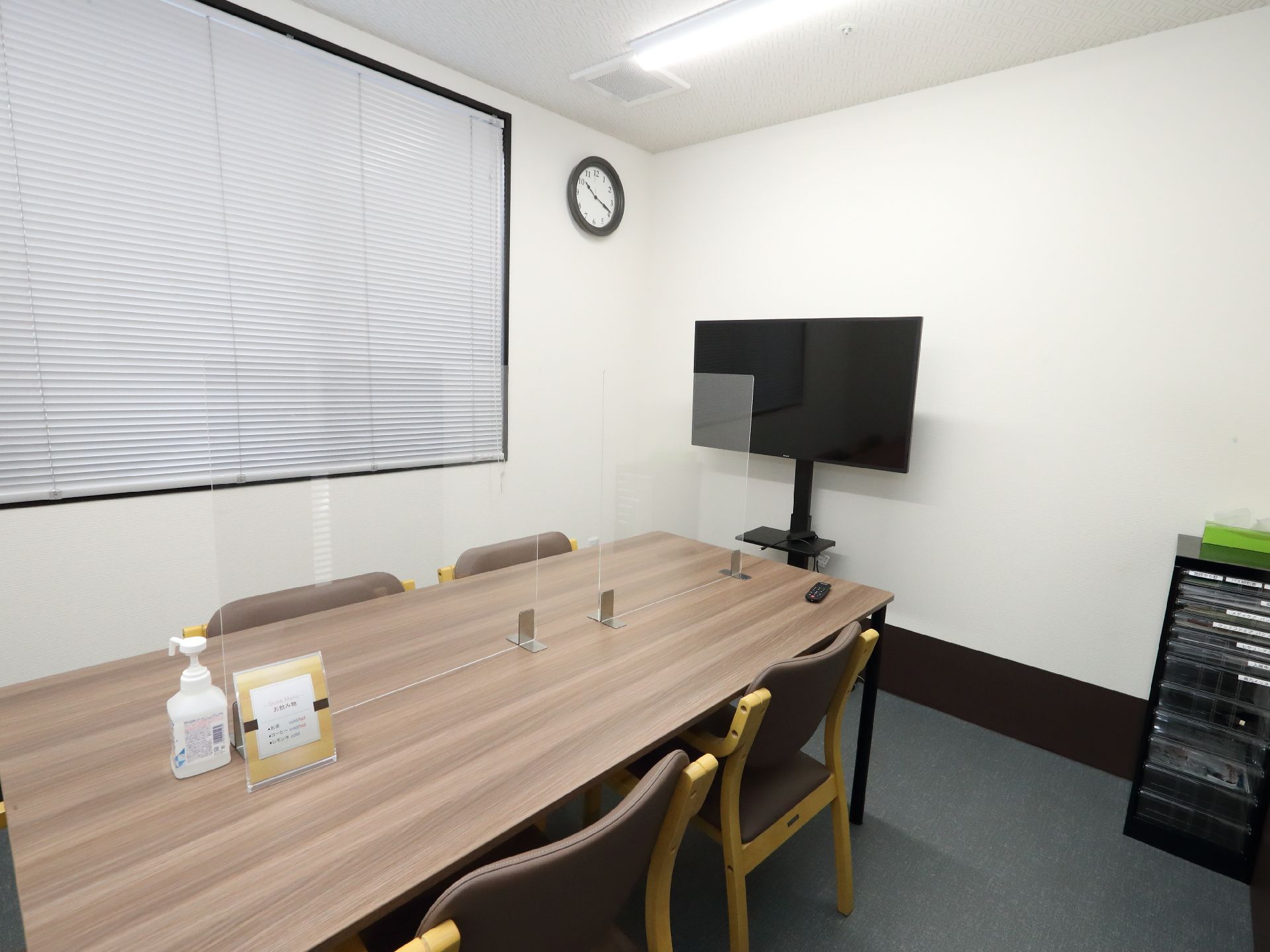 椅子と仕切り板がついているテーブルが設置された共有スペース