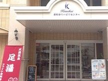 玄関には格子状の自動ドアが設置され、屋根が付き、屋根にはホーム名が書かれている。足湯と書かれた旗もある。