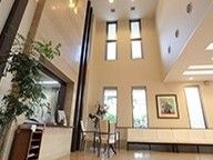 吹き抜けがある共有スペースには絵画や観葉植物が飾られ、テーブルセットも置かれている。