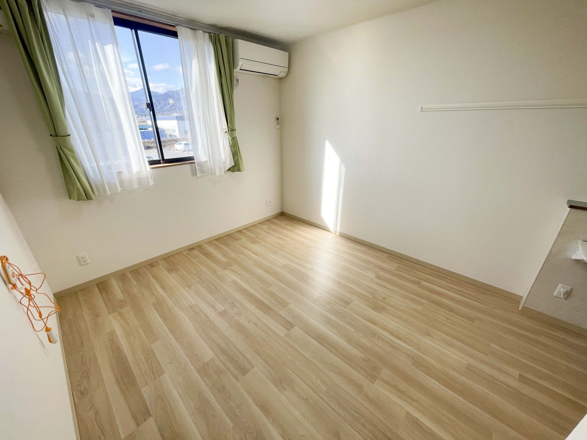 カルテのようなものを書き込みながら話しているエプロンを付けた若い女性スタッフとカーディガンを着た高齢女性。