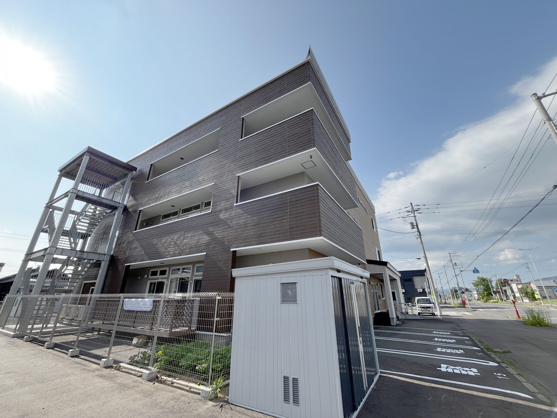 アジサイの貼り絵を楽しんでいるエプロンを付けた若い女性スタッフとカーディガンを着た高齢女性。