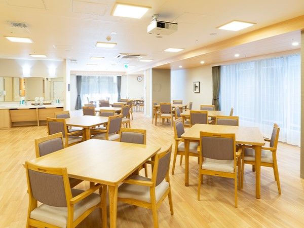 木製のテーブルと椅子が複数並べられた広い空間