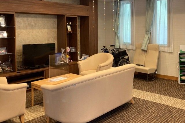 ベージュのソファセットと、テーブル、大型テレビが置かれている談話スペース