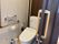 スライド式のドアが設置されているトイレにはオレンジの呼び出しボタンや手すりも付いている。