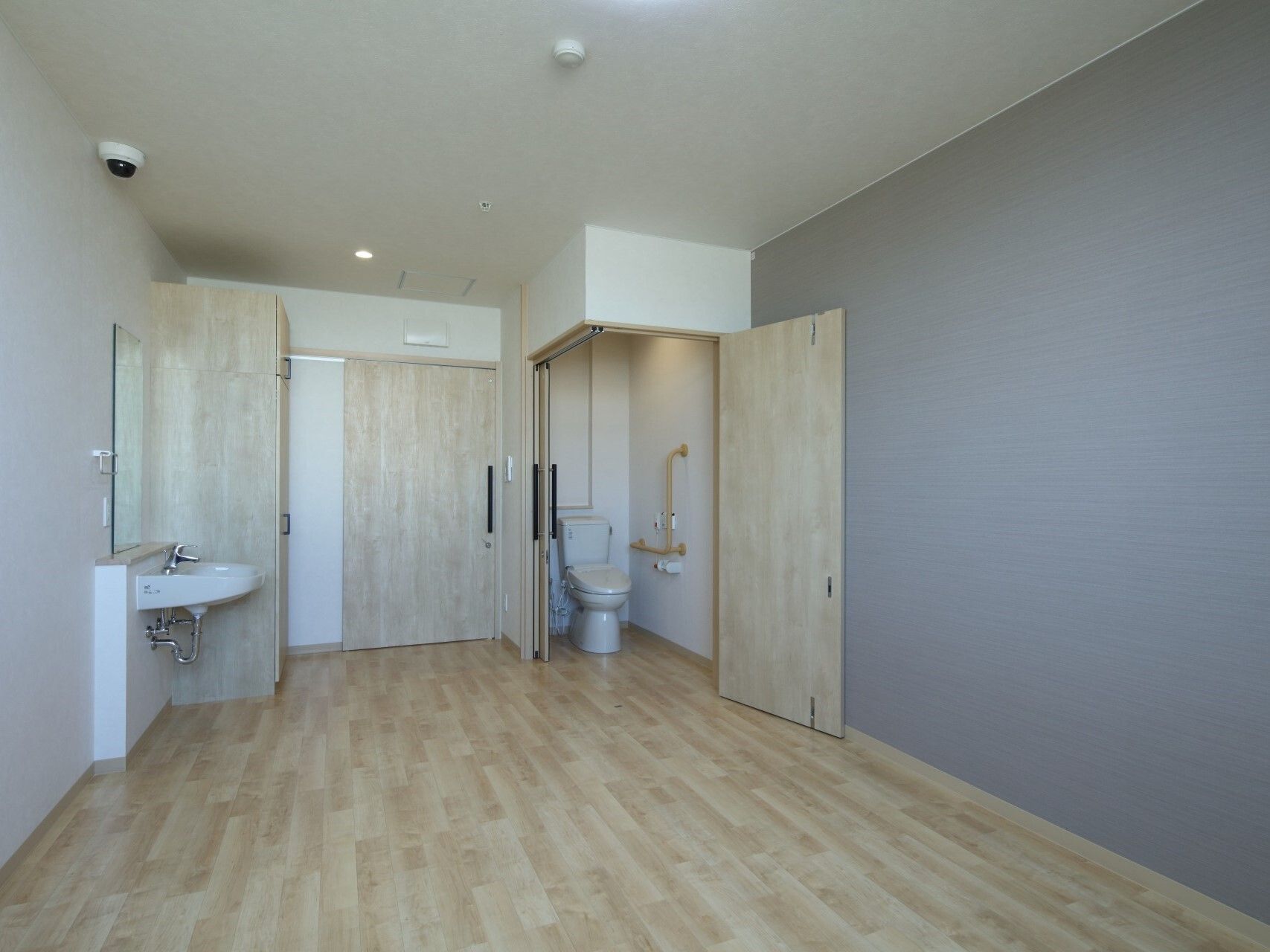 フローリングの部屋は車いす対応のトイレと洗面所付きで家具や家電は置かれていない。