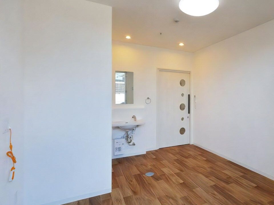 フローリングの部屋には家具や家電はなく、壁にはオレンジの緊急通報装置があり、洗面所付き。