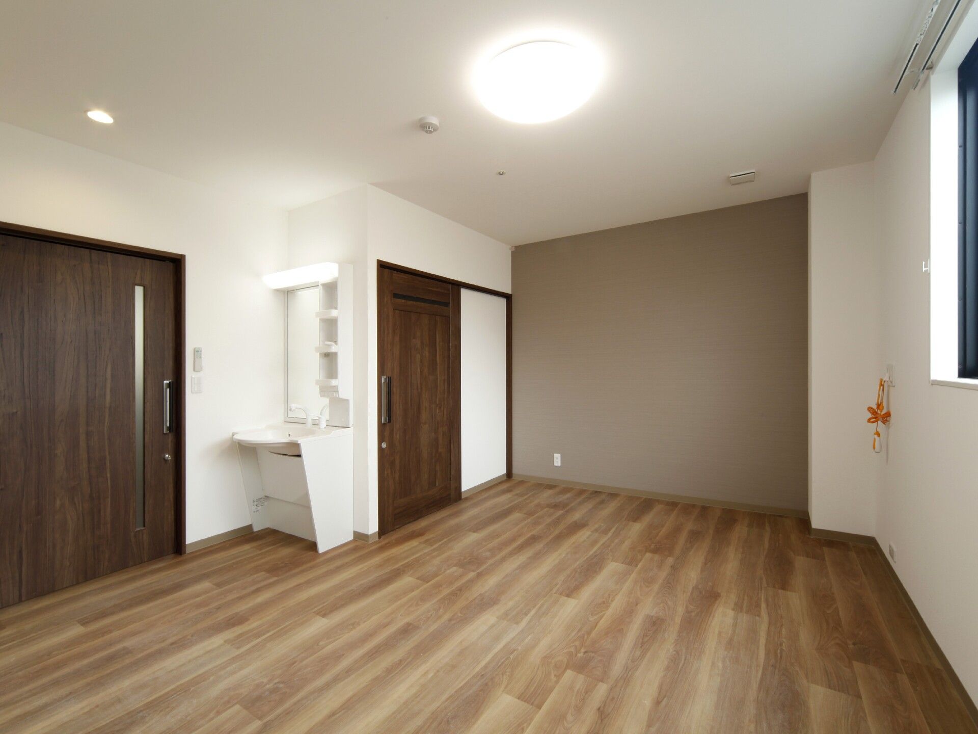 トイレや居室のドアはダークブラウンの引き戸で、フローリングの部屋には洗面所もある。