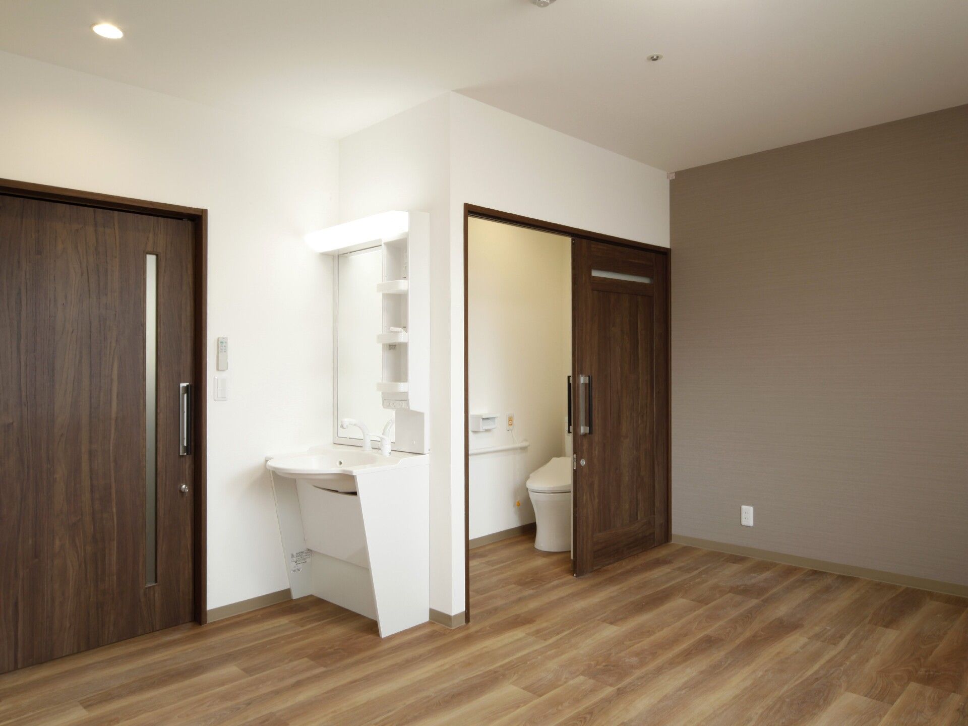 フローリングの部屋には洗面所とトイレがあり、トイレのドアは開けられている。