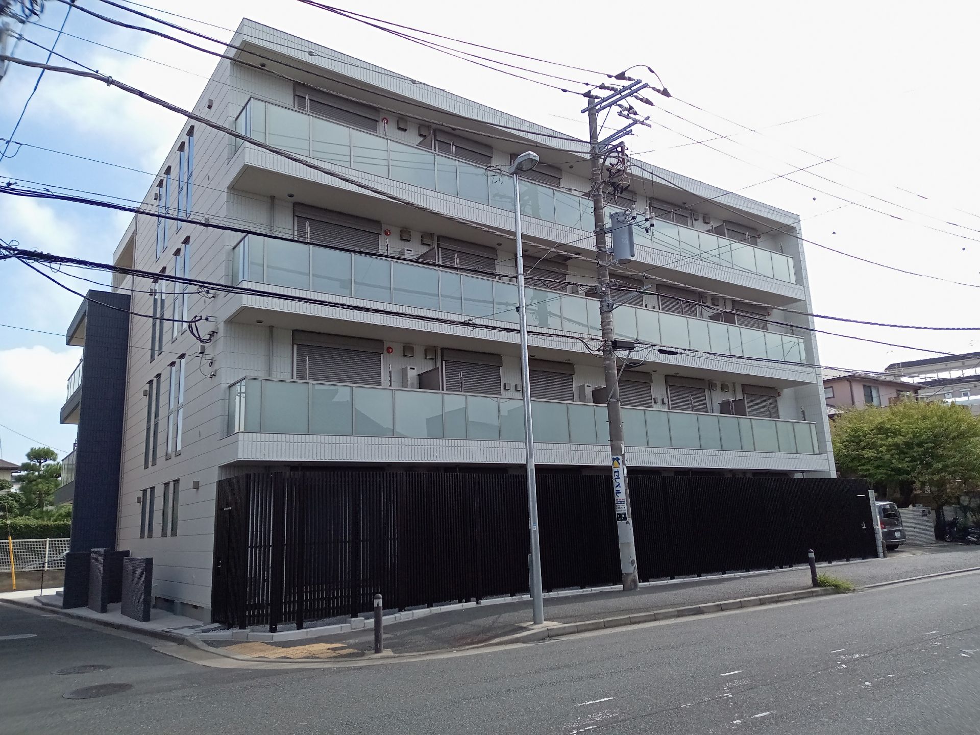 4階建ての建物は道路に面していて、周囲には緑も残っている。各フロアにベランダが付いている。