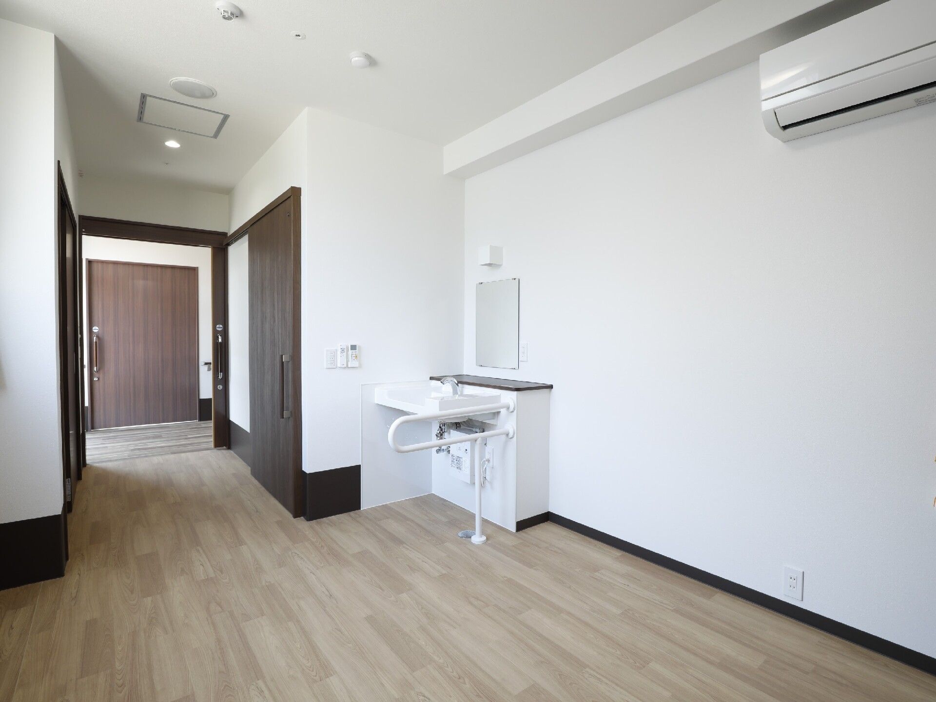 エアコンが付いたフローリングの部屋には車いす対応の洗面所やトイレがある。