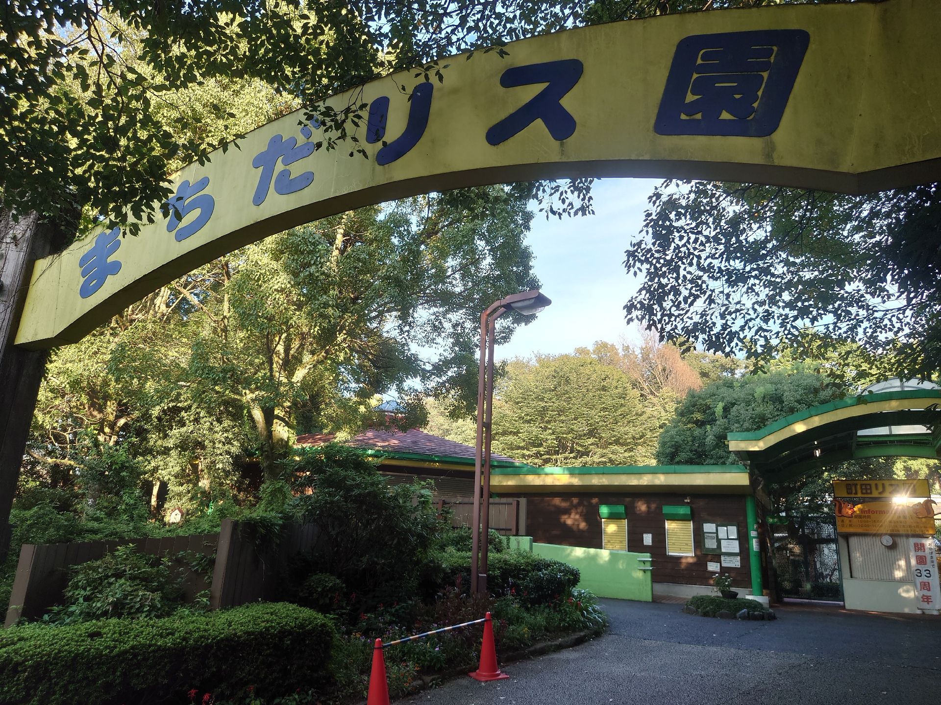 「まちだリス園」とか書かれた大きな門をくぐるとチケット売り場などがあり、その奥には緑が広がっている。