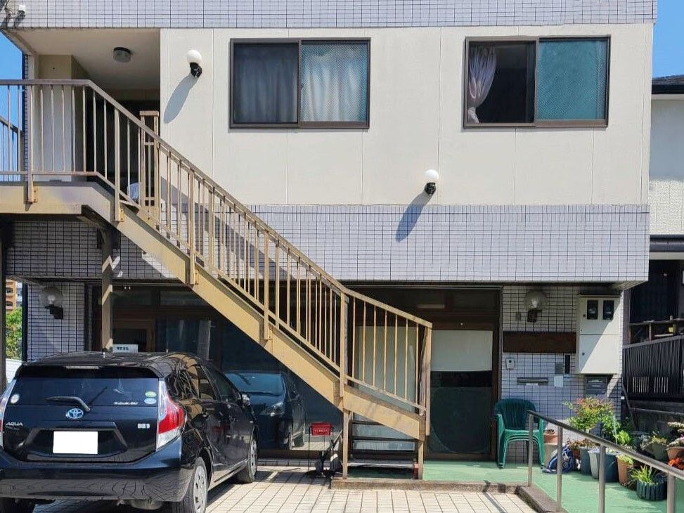 建物は日当たり良好で屋外階段が設置され、玄関先には手すりが付いている。