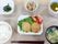 メインのフライに野菜が添えられ、白いご飯に味噌汁、お茶、野菜の小鉢が並んでいる。