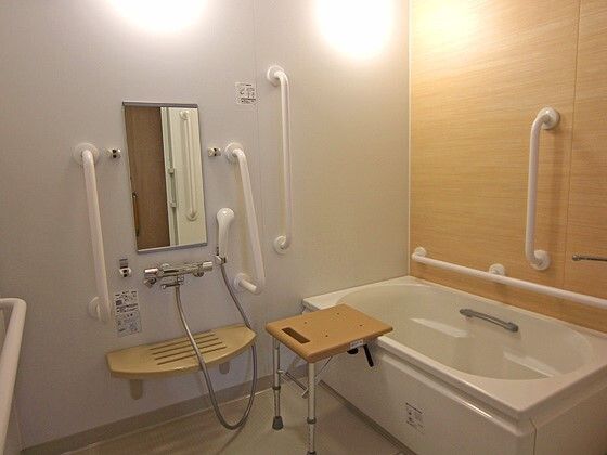 窓が付き、洗い場の広い浴室には大き目の浴槽とリフトがあり、浴槽には手すりがある。