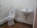 広いトイレ内にはシンプルなデザインの便座が設置されたトイレがあり、手洗い場も付いている。