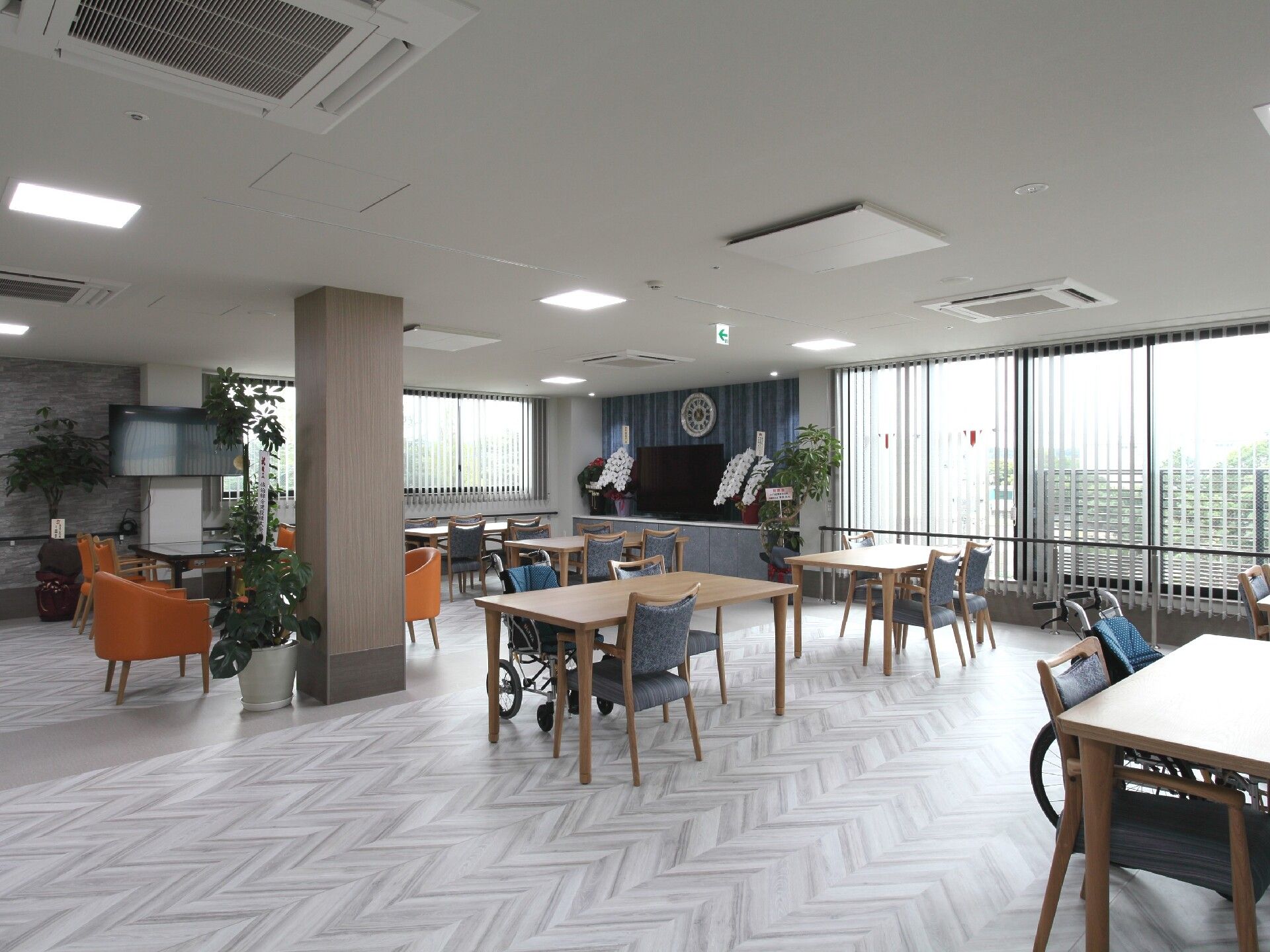 4人掛けのダイニングテーブルセットが複数置かれた食堂。大きな窓が付き、テレビも設置されている。