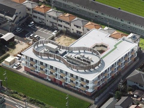 上空から見た屋上が特徴的で、多くの緑に囲まれている施設建物