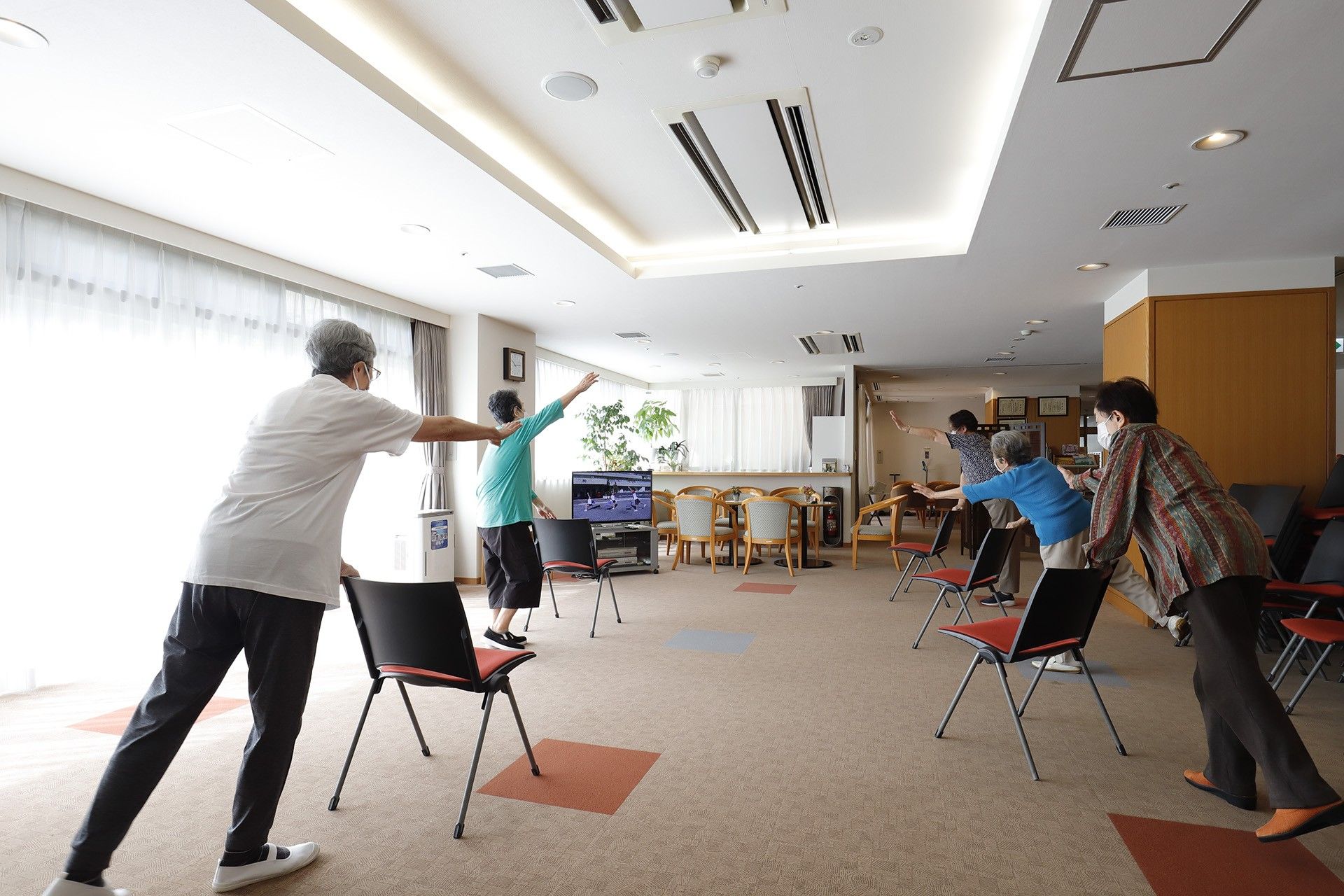 大きな鏡が設置された洗面台があり、隣には洋式便器が置かれている。壁側には柵が取り付けられており、窓もある。
