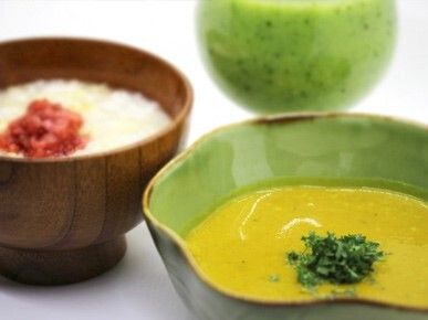 刻みパセリのようなものが散らされたソフトグリーンのスープのようなものと梅干が乗ったおかゆ。