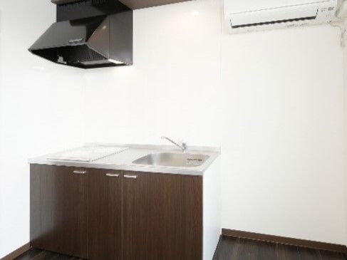 IHクッキングヒーター付きのキッチンが設置された部屋にはエアコンも付き、小物などは持ち込まれていない。