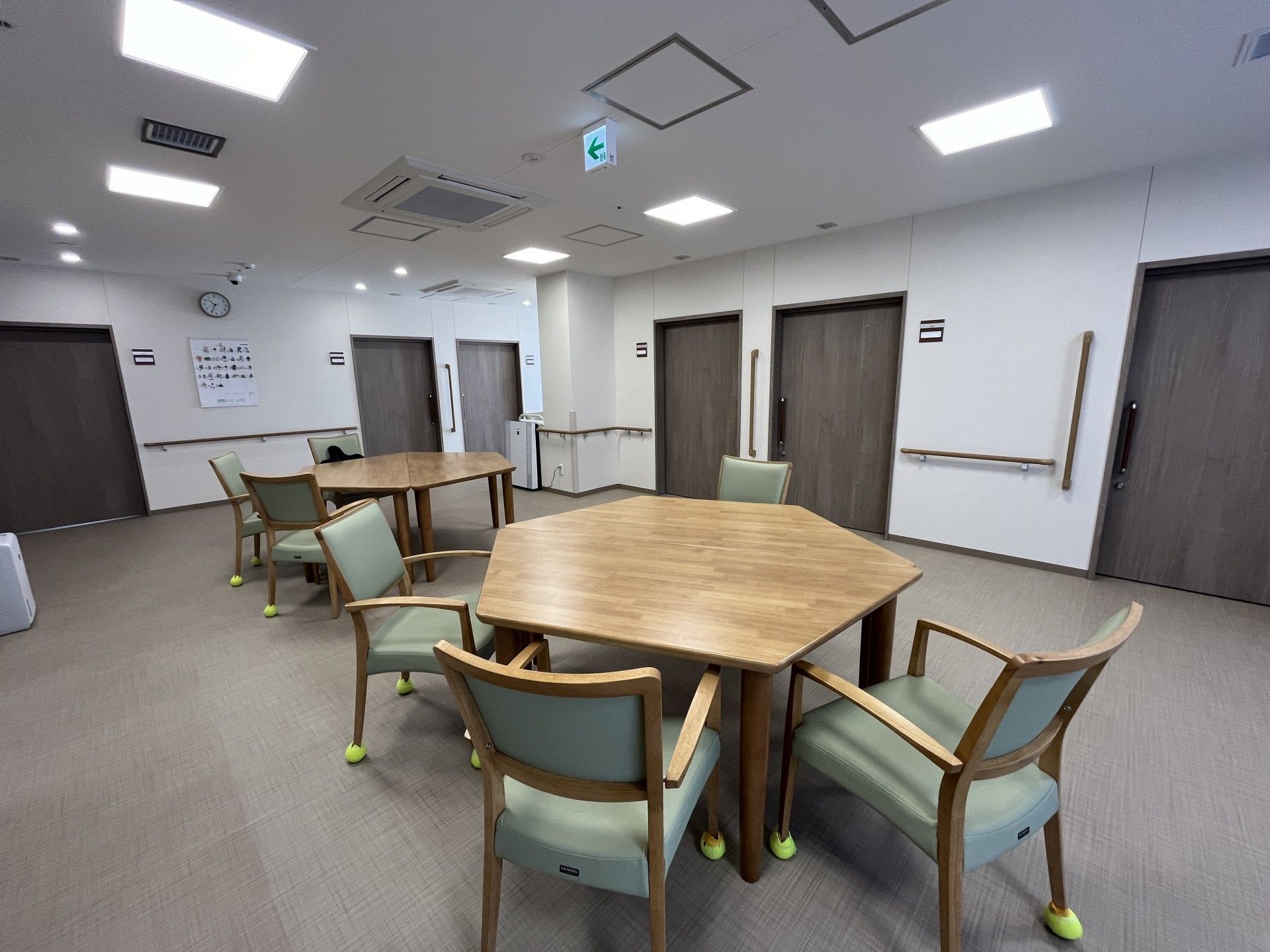 ジャケットを着た高齢女性とエプロンを付けた女性スタッフが笑顔で街中を歩いている。
