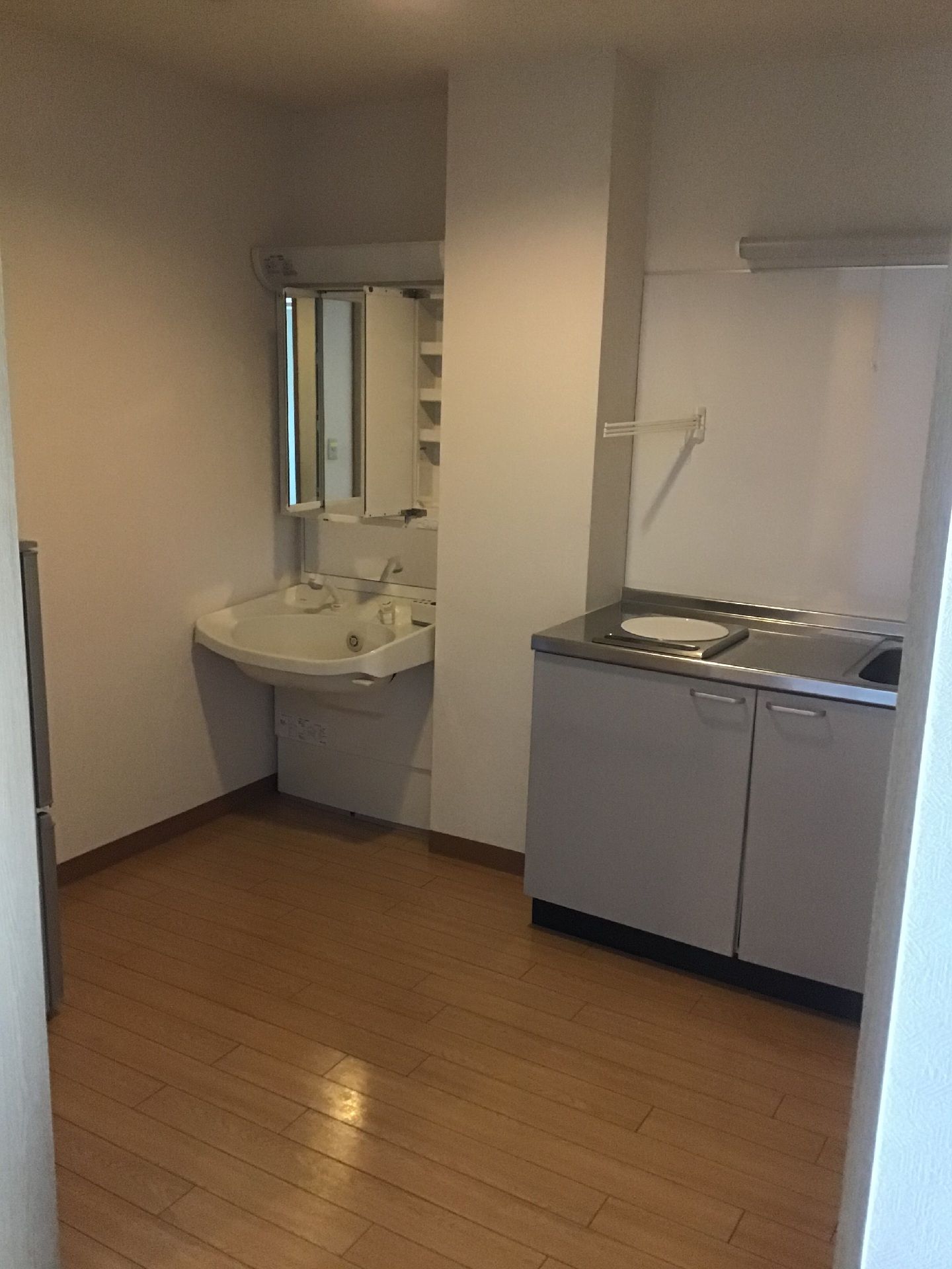 手すり付きのトイレや洗面所が設置された居室。トイレのドアはスライド式でトイレ内にはタオル掛けもある。