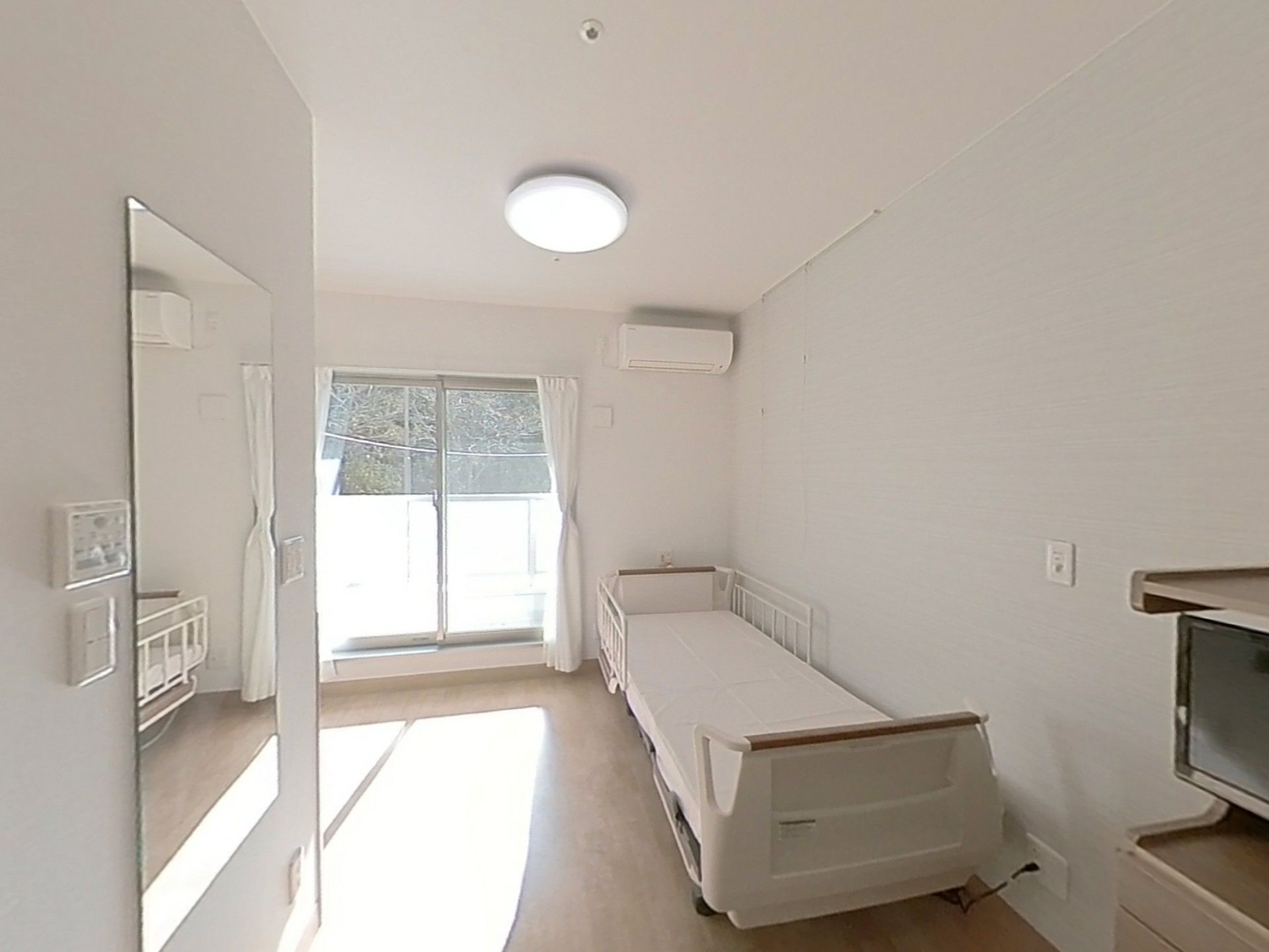 電子レンジや冷蔵庫がキッチンのそばにあり、ワンルームタイプの部屋にはベッドやテレビも置かれている。