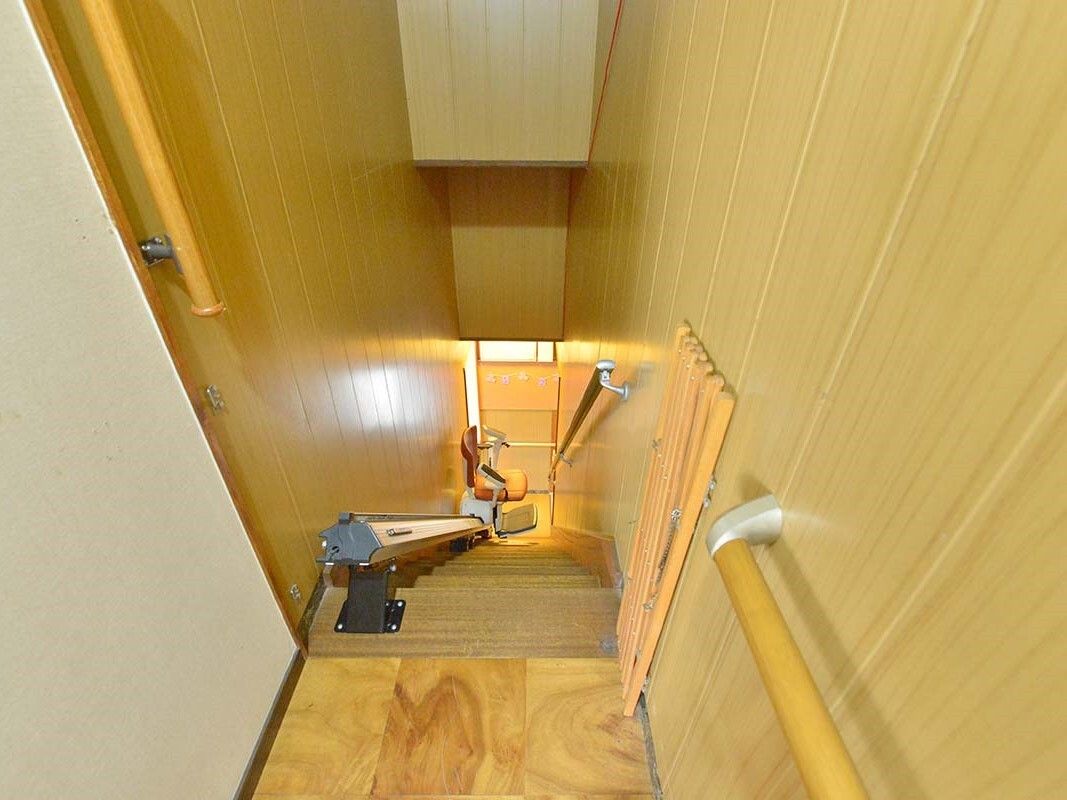 手すりが付いた一般の住宅と変わらない幅の階段には昇降機を設置している。