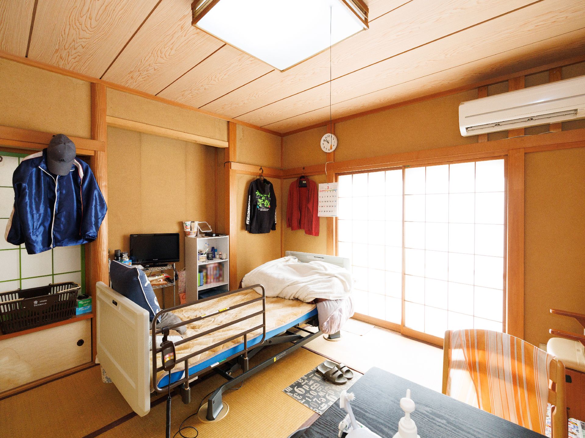 窓から日差しが降り注ぎ、介護ベッドや家具に光が当たっている居室